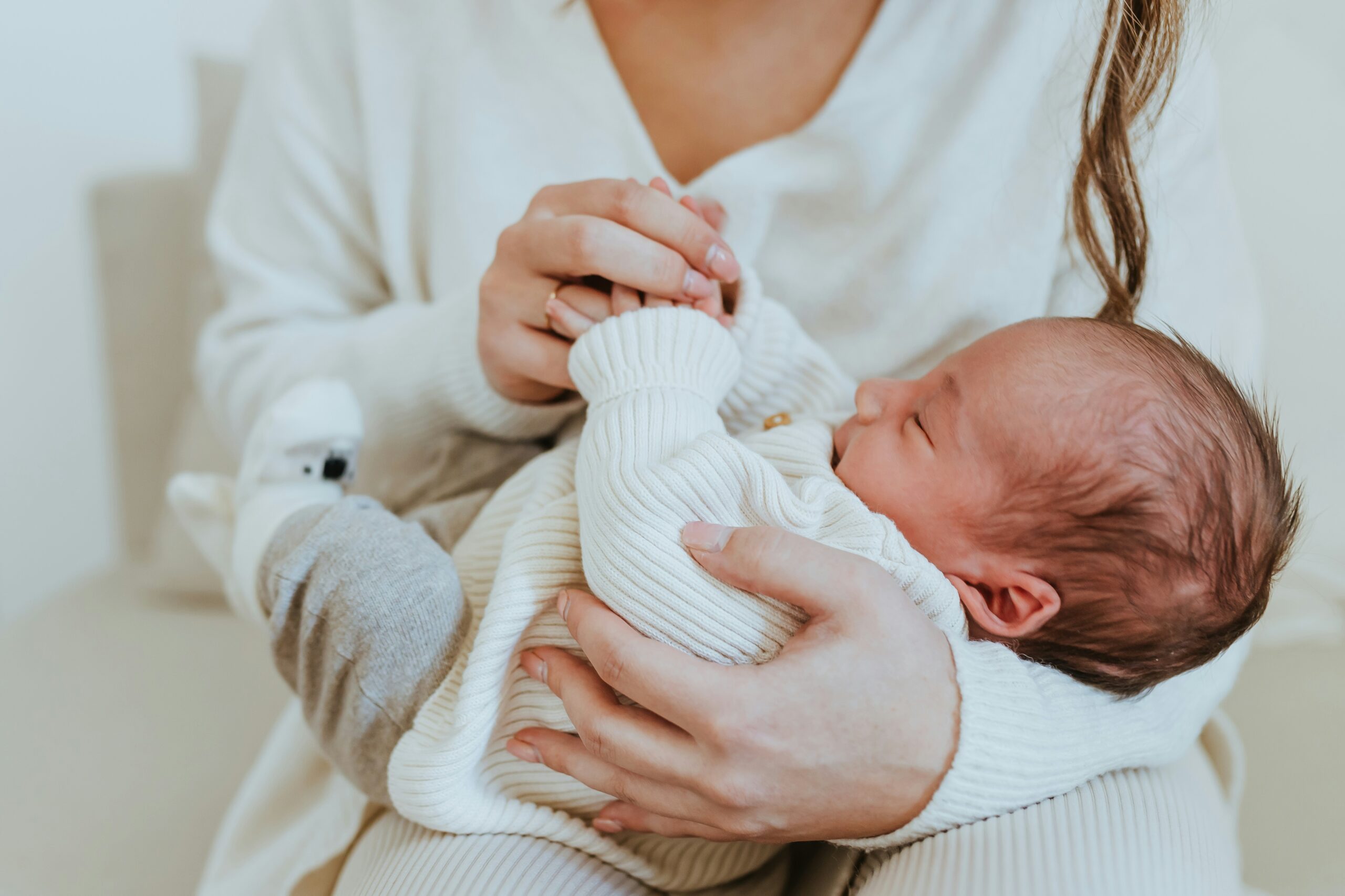 Newborn resting in a caregiver's arms